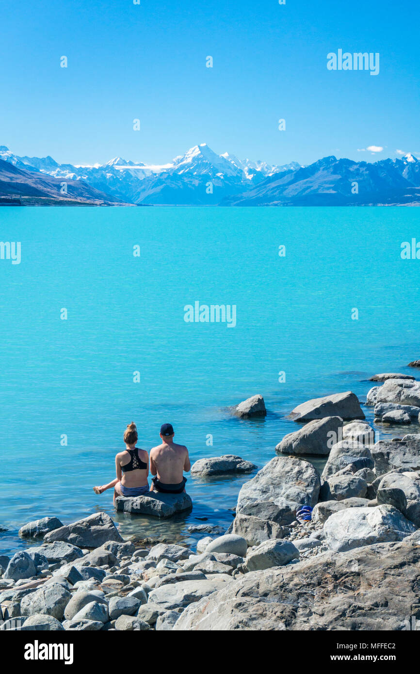 Nuova Zelanda Isola del Sud della Nuova Zelanda giovane sat guardando il Mount Cook dal lato del Lago Pukaki parco nazionale di Mount Cook Nuova Zelanda Foto Stock