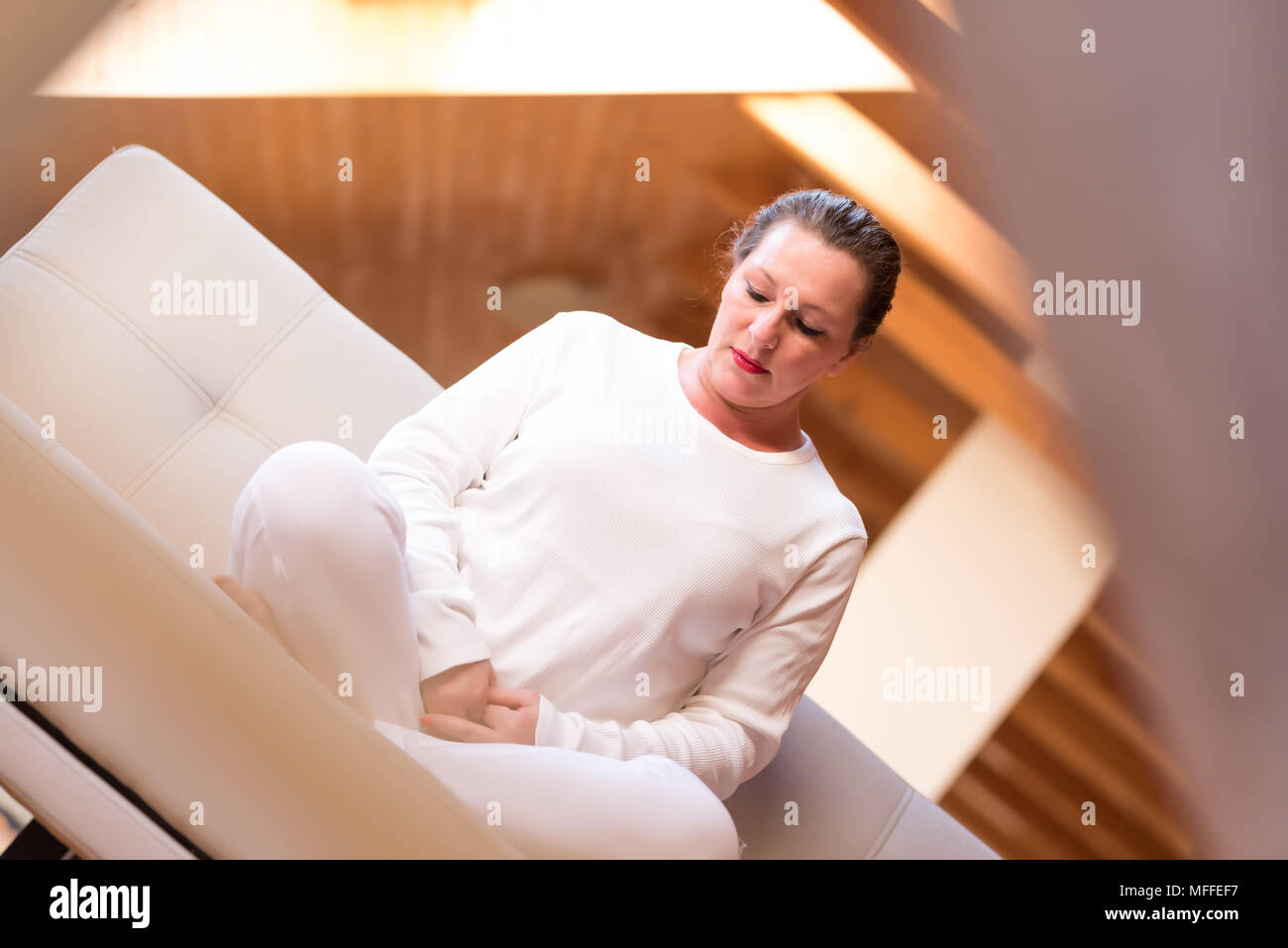 Ritratto di una donna di mezza età meditando nel suo appartamento in mansarda. Foto Stock
