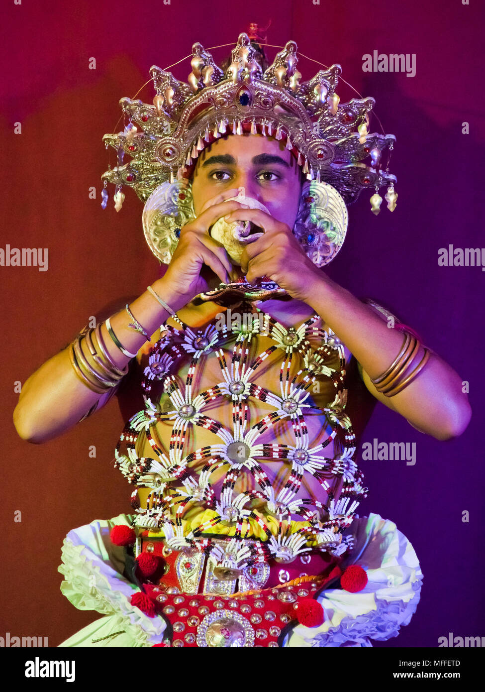 Ritratto verticale di un ballerino Kandyan giocando una conchiglia, Kandy, Sri Lanka. Foto Stock