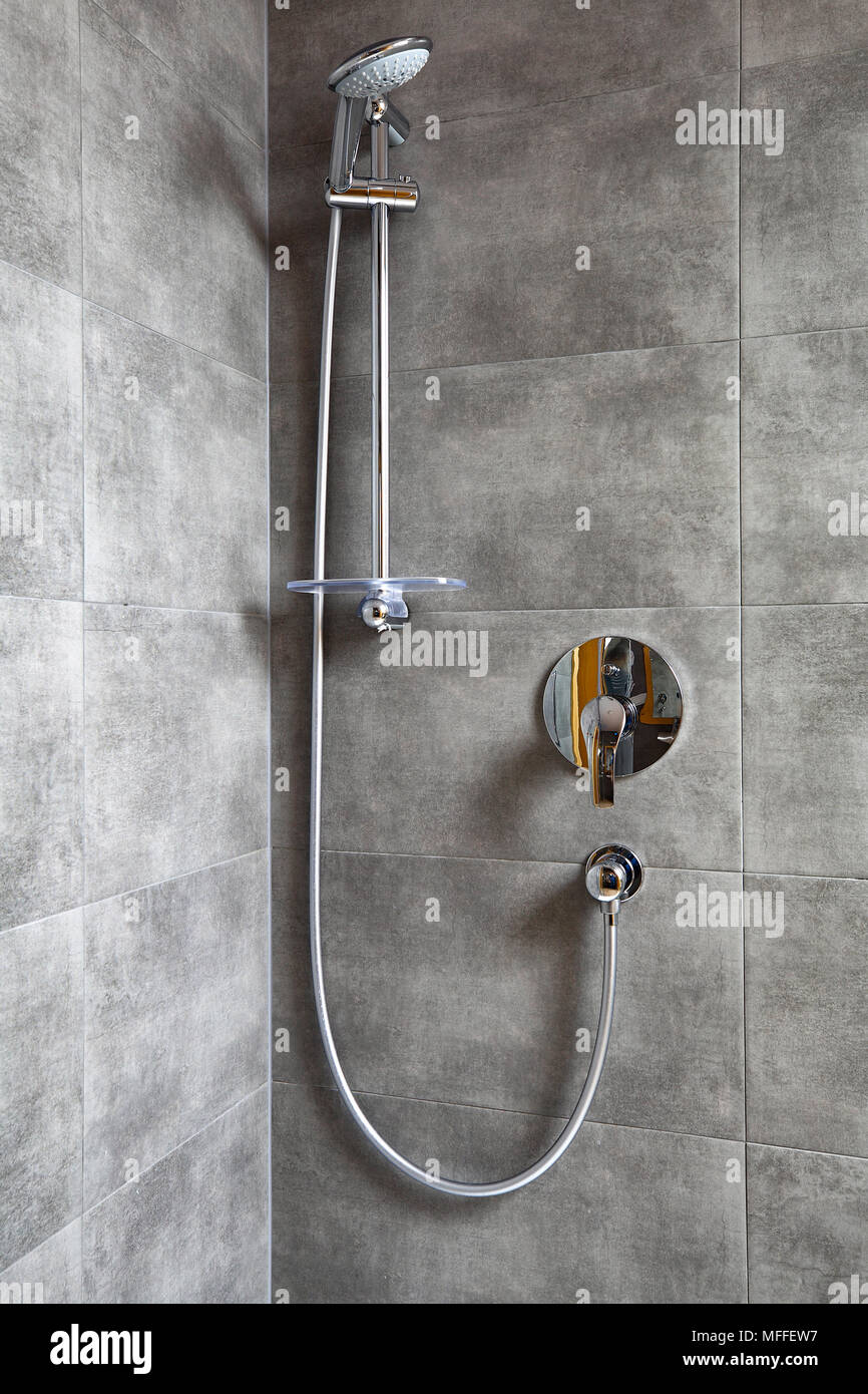 Nuovo shiny doccia moderna in cabina doccia. Bagno con piastrelle grigio. Foto Stock