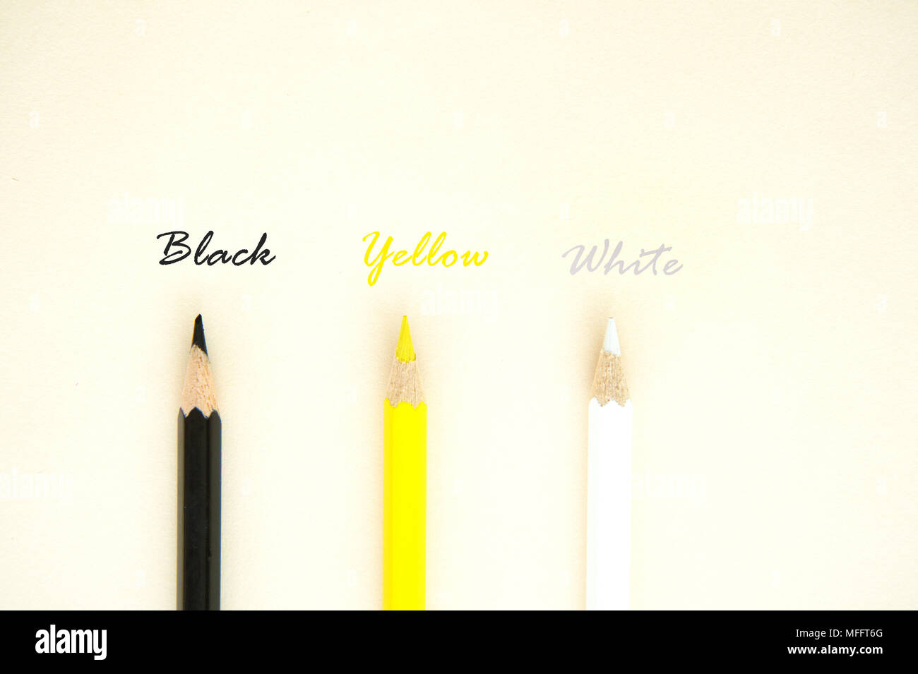 Colorata giallo nero matita bianca a colori con testo lettera su carta di colore beige per la cute umana equity sfondo concept Foto Stock