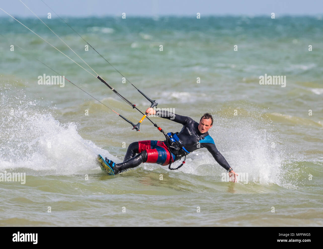 Uomo di Kitesurf in mare. Sport acquatici. Kitesurfer sporgendoti tenendo con una mano. Foto Stock