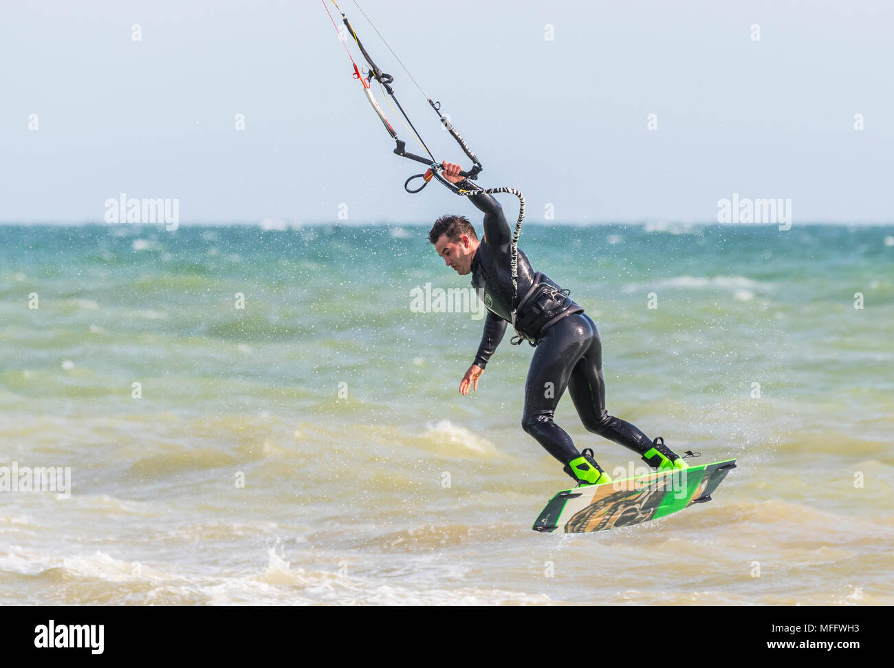 Uomo di Kitesurf in mare e prendendo il largo tenendo con una mano. Kitesurfer sull'oceano. Sport acquatici. Foto Stock