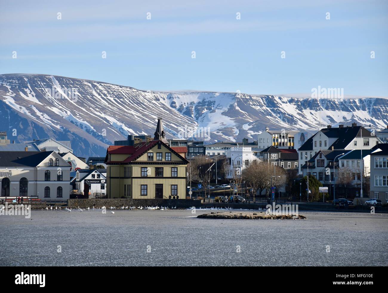 Vista di Reykjavik Islanda su lago ghiacciato con montagne innevate sullo sfondo Foto Stock