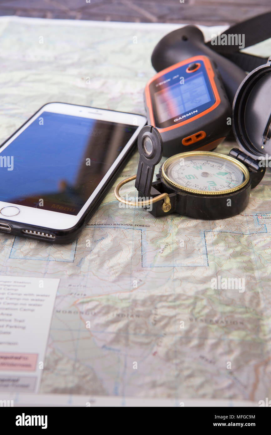 Numerosi dispositivi di navigazione portatili per escursioni: Asta da  trekking, mappa, bussola, iPhone con un'app gps e un GPS Garmin Foto stock  - Alamy