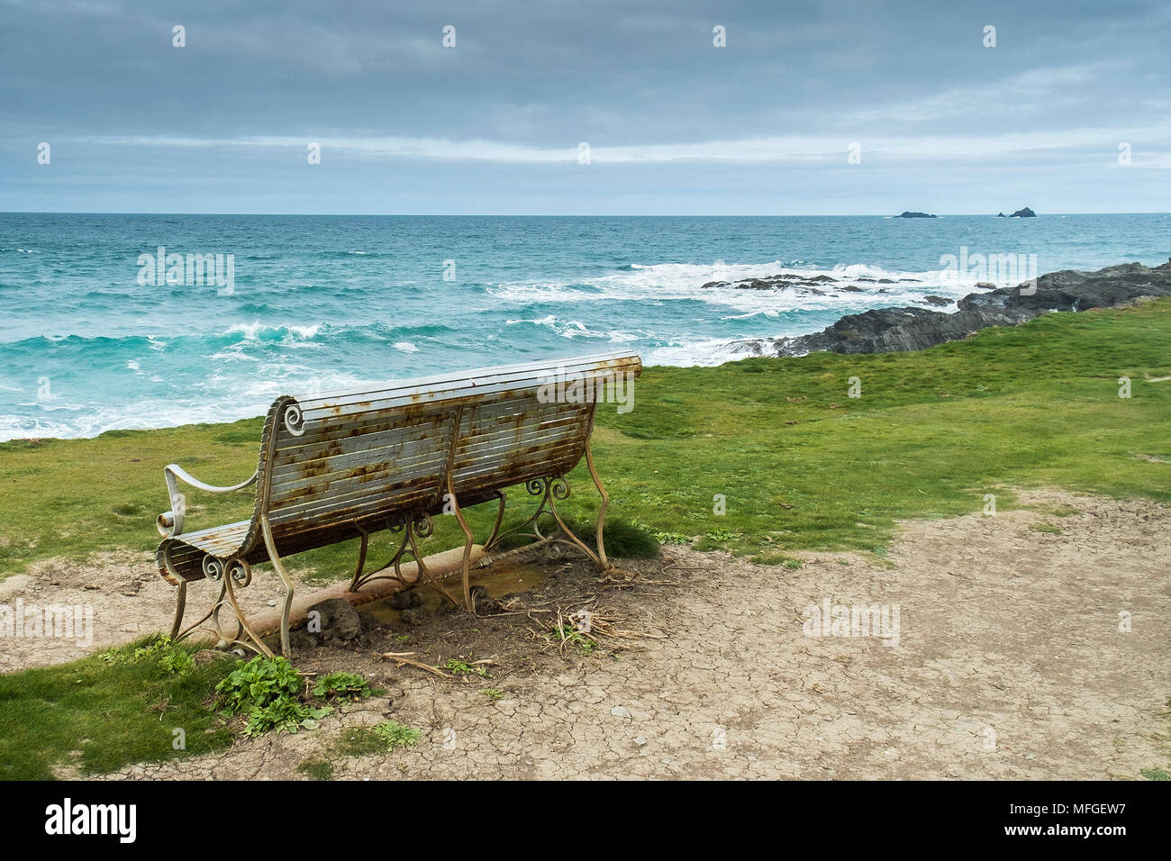 Un ornati in ferro battuto panca sulla costa che si affaccia sul mare del Nord della Cornovaglia costa. Foto Stock