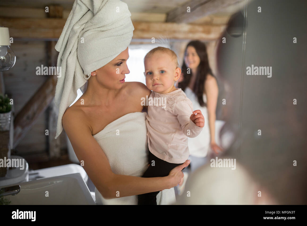 Ritratto di donna avvolto in asciugamani holding baby Foto Stock