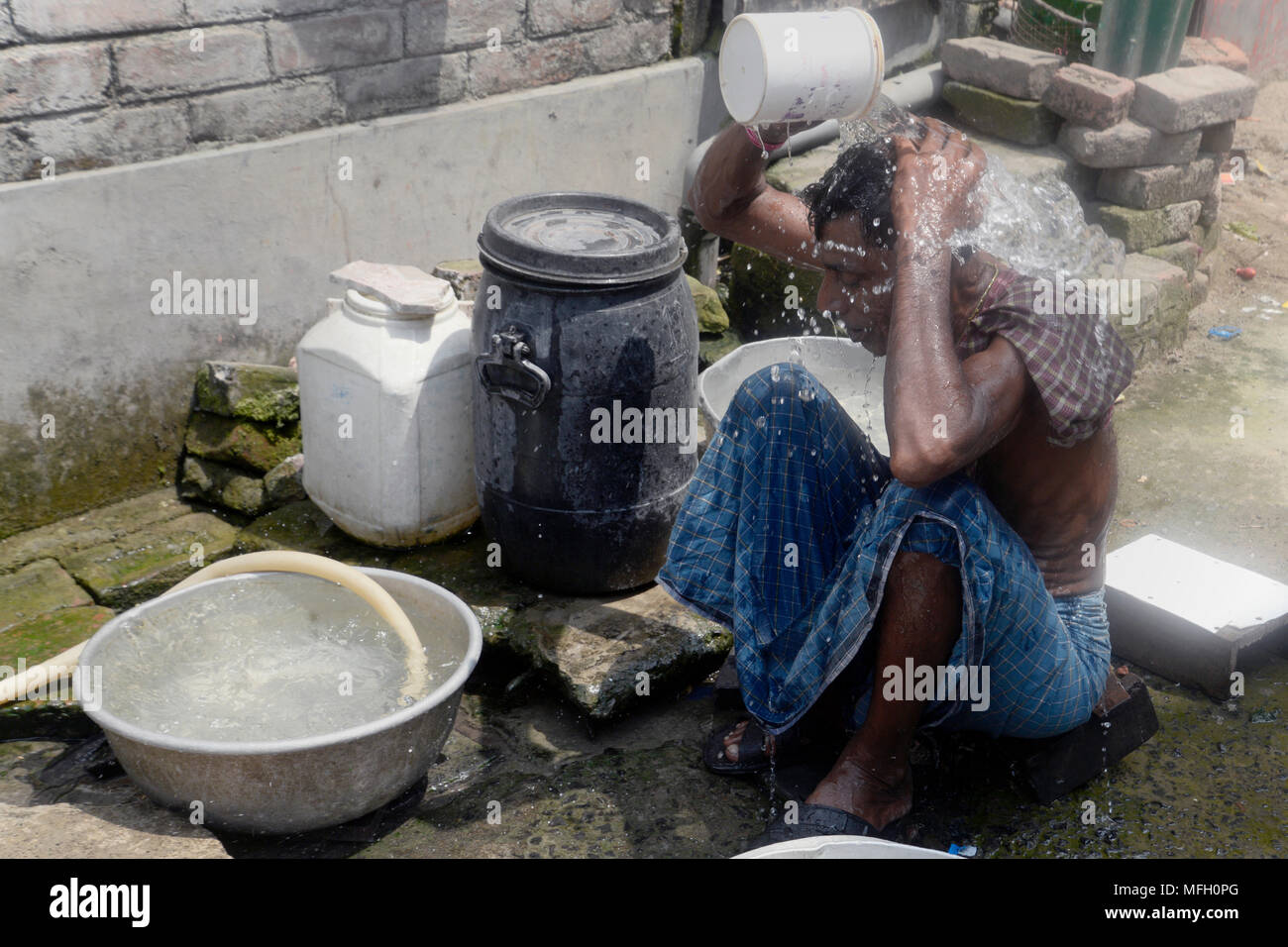 Kolkata, India. Xxv Aprile, 2018. Indian uomo prende bagno a street a raffreddarsi a causa di tempo caldo condizioni. L'avvento di estate nel Bengala occidentale e in India ha portato onda di calore come le condizioni con l'aumentare della temperatura record nel paese. Credito: Saikat Paolo/Pacific Press/Alamy Live News Foto Stock
