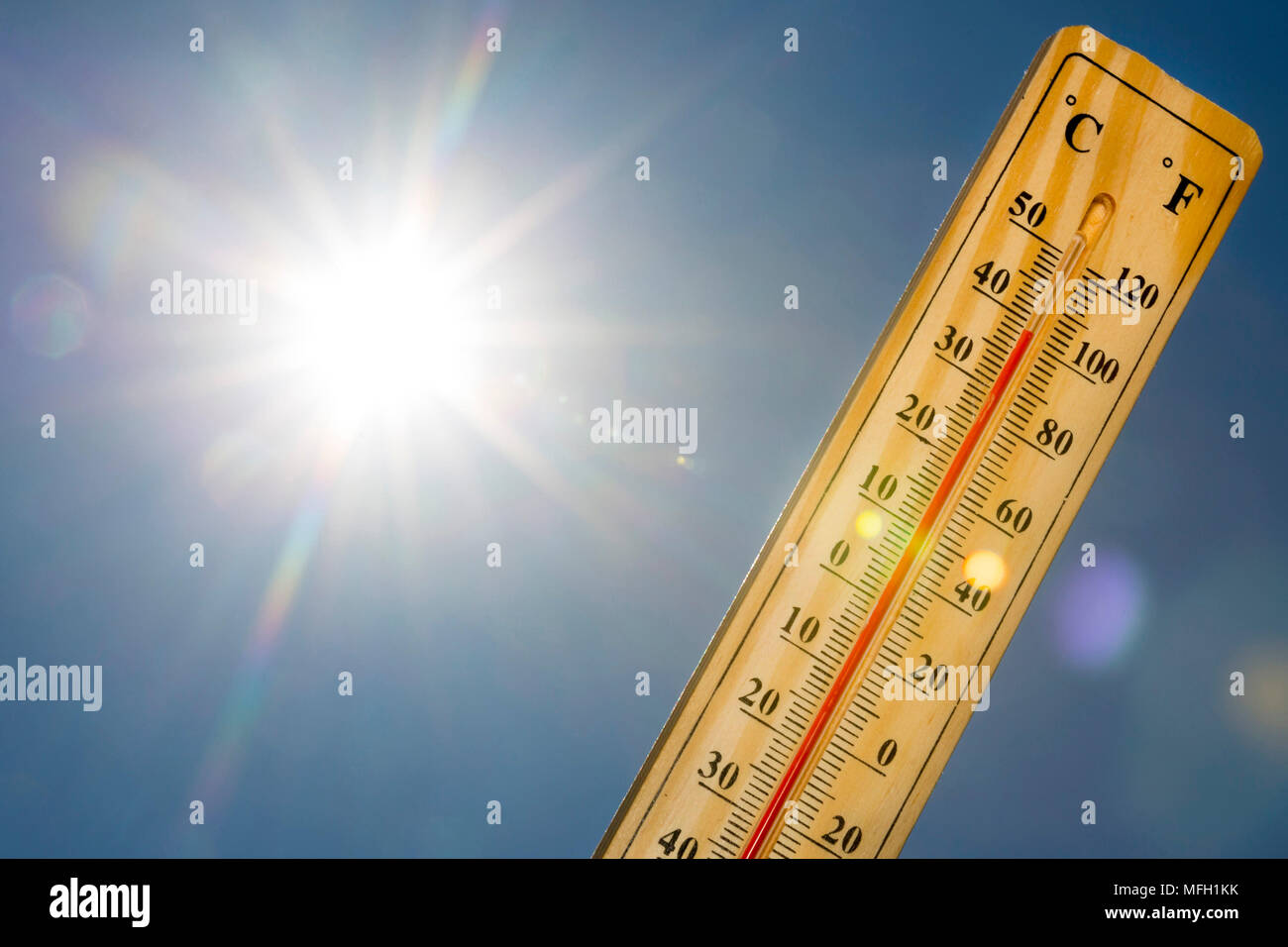Termometro a mercurio marcatura 39 gradi Celsius, 100 gradi Fahrenheit in una giornata di sole. L'estate calore mostrato sul termometro a mercurio contro il cielo blu. La luce del sole Foto Stock
