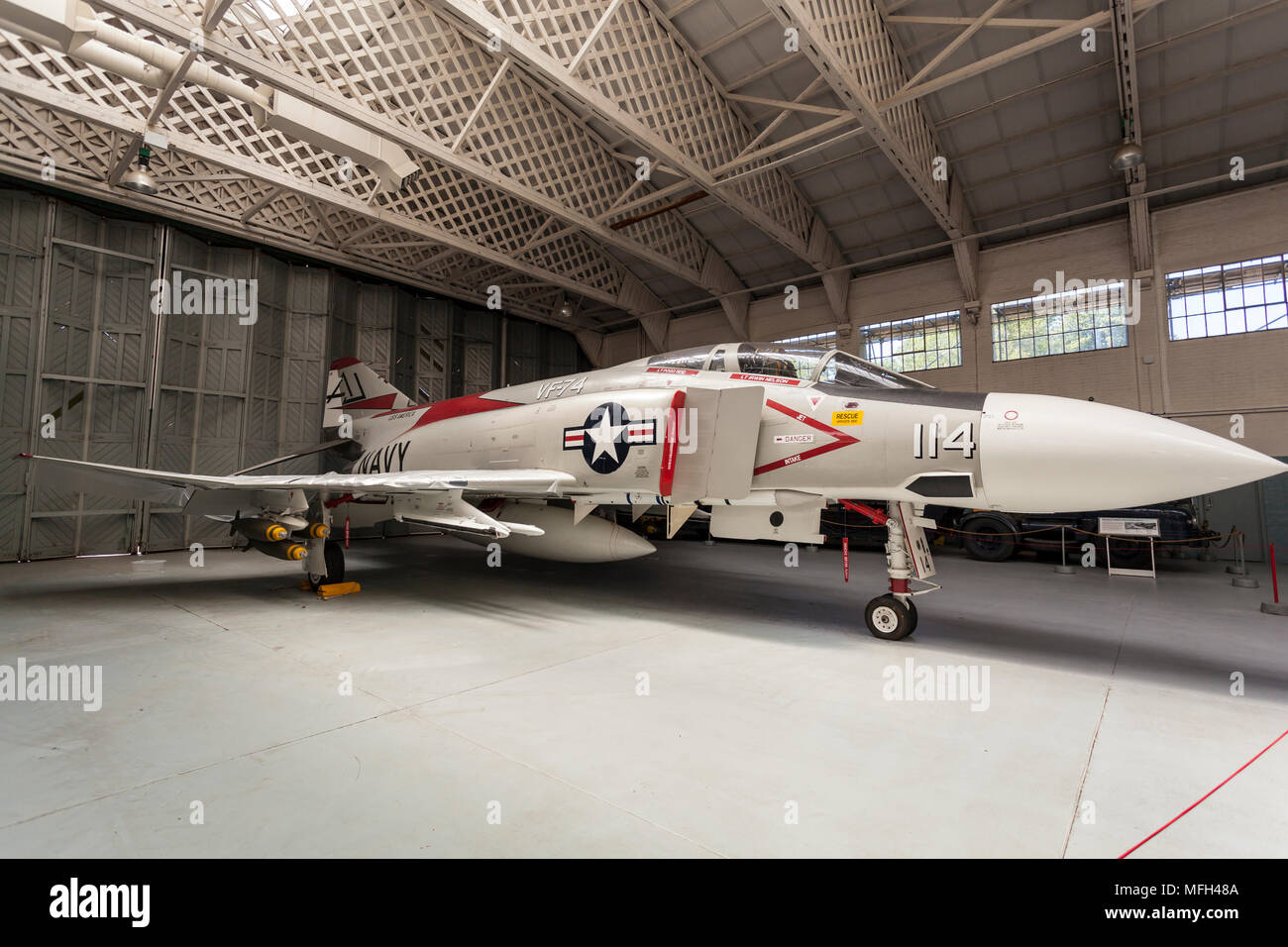 Duxford Air Museum. Inghilterra, Regno Unito. Un US Navy Phantom fighter piano sul display in un aeromobile appendiabiti. Foto Stock