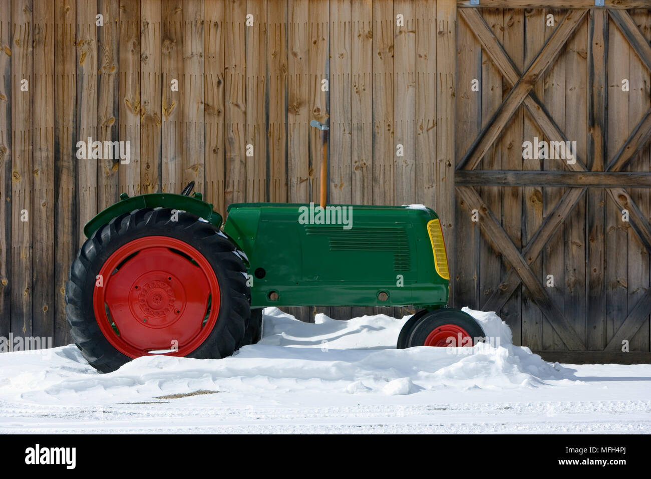 Oliver Antico trattore nella neve un vecchio fienile Vermont Foto Stock