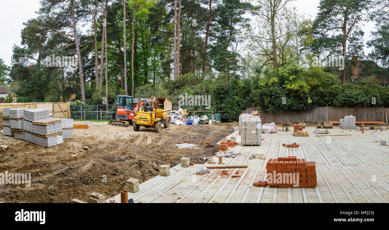 Hitachi impianto pesante escavatore meccanico e Thwaites dumper dalla soletta di una nuova casa in costruzione su un edificio sito nel Surrey, SE Inghilterra Foto Stock