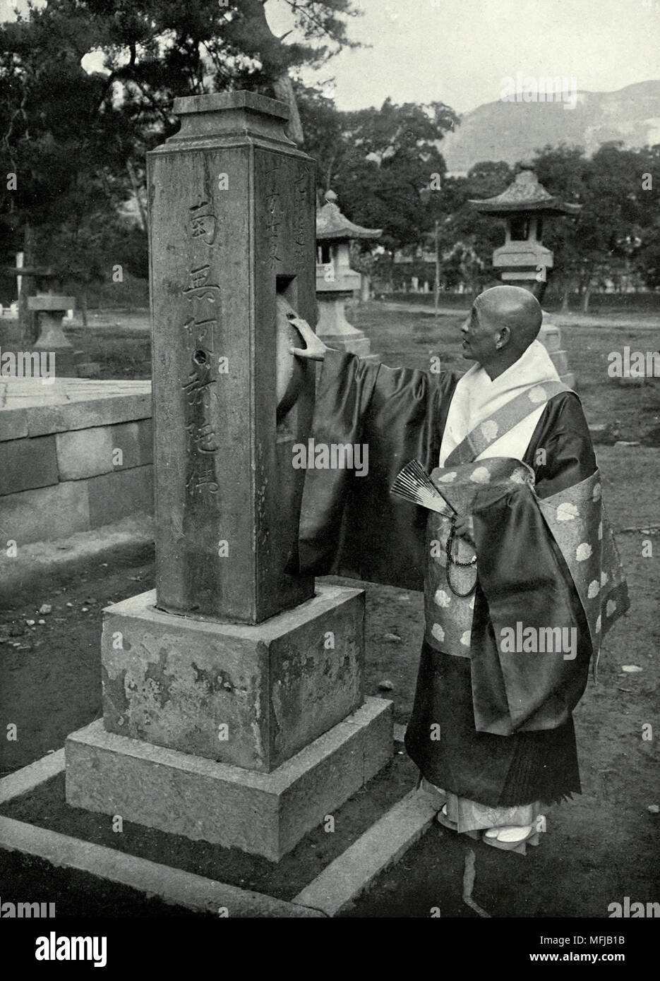 Un prete buddista e pregando ruota in Giappone, circa 1910 Foto Stock