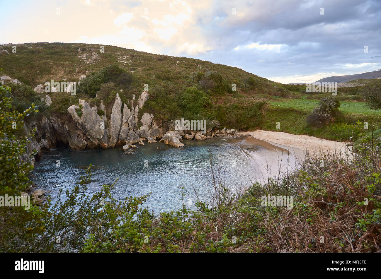 Tramonto sulla spiaggia di Gulpiyuri, che è una spiaggia interna sornata in una dolina alluvionata creata dall'erosione carsica (mare Cantabrico, Naves, Llanes, Asturie, Spagna) Foto Stock