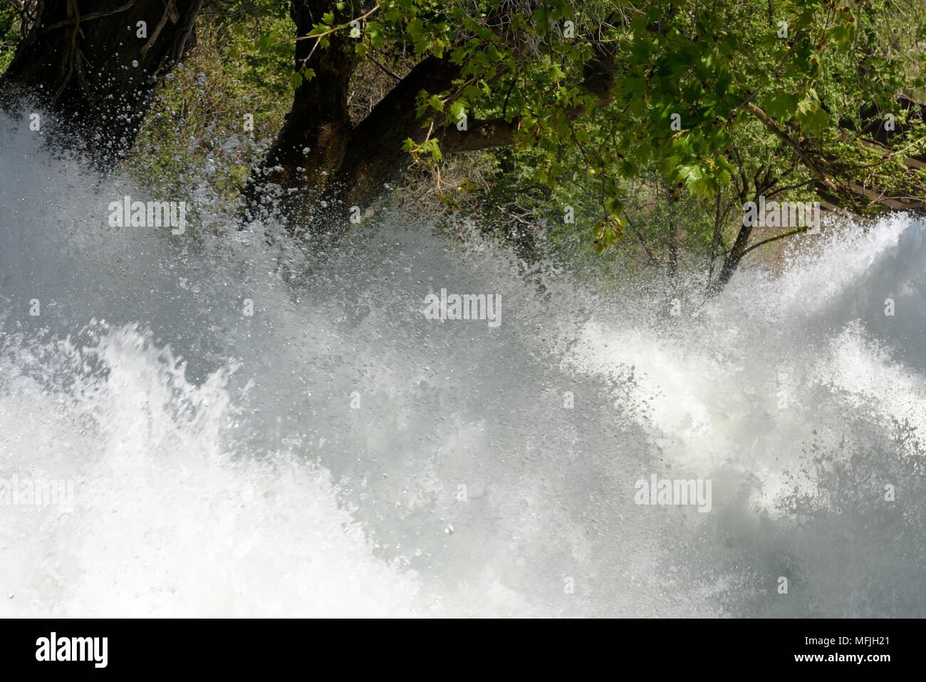Close-up di acqua turbolenta o flusso di fiume che scorre attraverso i boschi Foto Stock