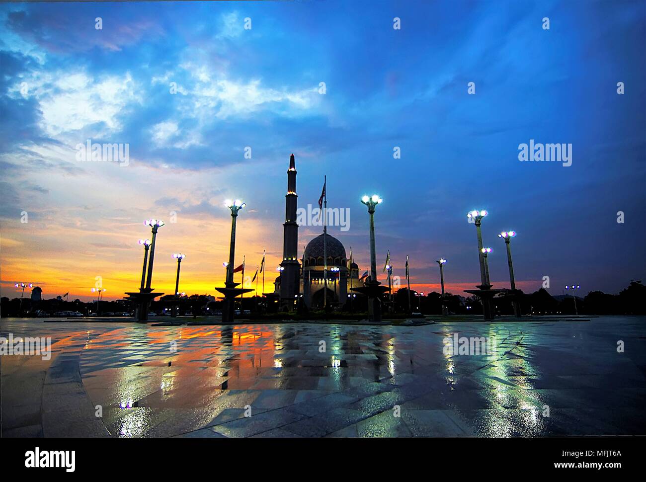 Glorioso tramonto al Putra Moschea, La moschea principale di Putrajaya, Malaysia, adottate dopo il diluvio. Visto qui riflessa del granito bagnato di Putra Foto Stock