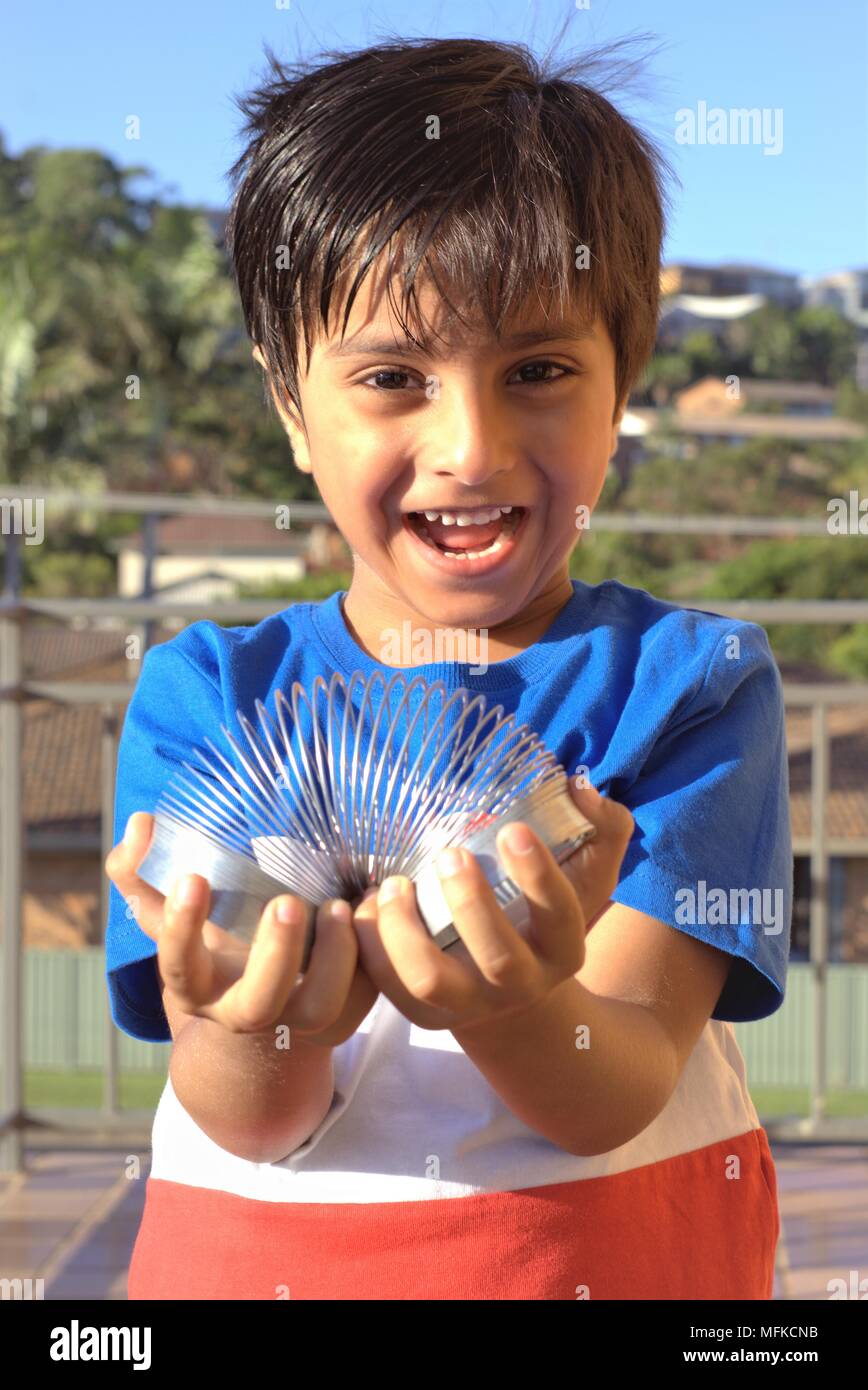 Kid giocando con molla giocattolo. Kid divertirsi giocando con il giocattolo molla elicoidale. Foto Stock