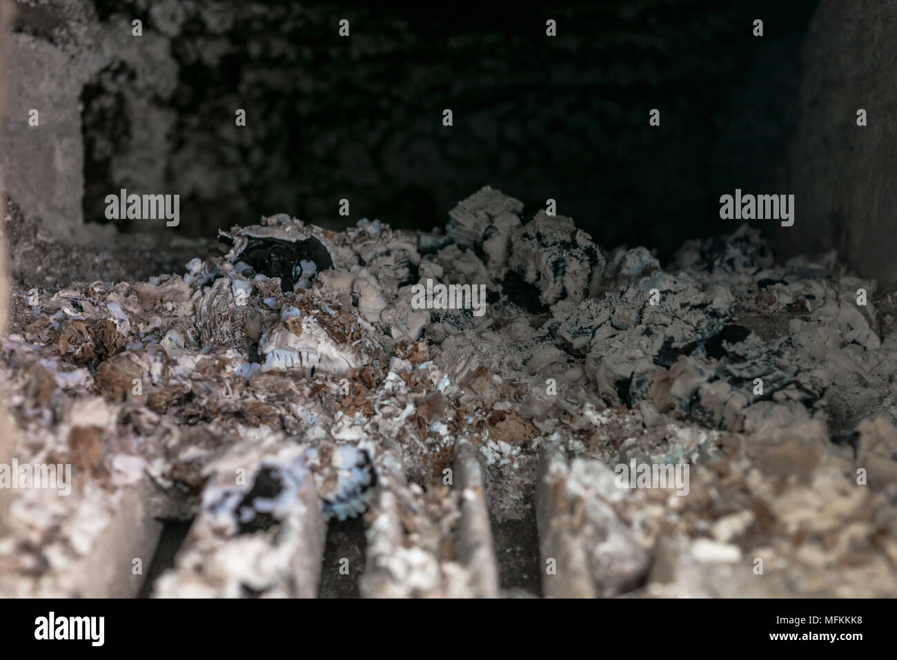 Vista di all'interno della stufa rurale con un sacco di ceneri e carbone di legna Foto Stock