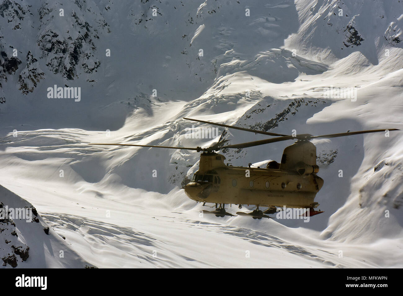 Un CH-47F elicottero Chinook dalla società B, 1° Battaglione, 52nd reggimento aviazione vola attraverso l'Alaska Range 22 aprile 2018. Avieri dalla porta dello zucchero fornito un assist a servizio del parco nazionale da battenti migliaia di sterline di apparecchiature e materiali di consumo da Talkeetna a NPS campo base a 7.000 a livello del piede del ghiacciaio Kahiltna in preparazione per il 2018 Denali stagione di arrampicata. (Esercito foto/John Pennell) Foto Stock