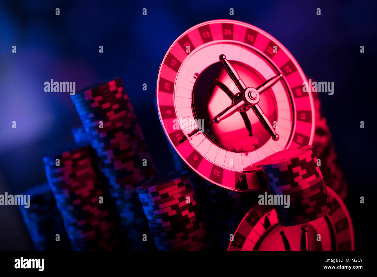 Giochi d'azzardo tema. Roulette e Poker chips su colorato sfondo bokeh di fondo. Foto Stock