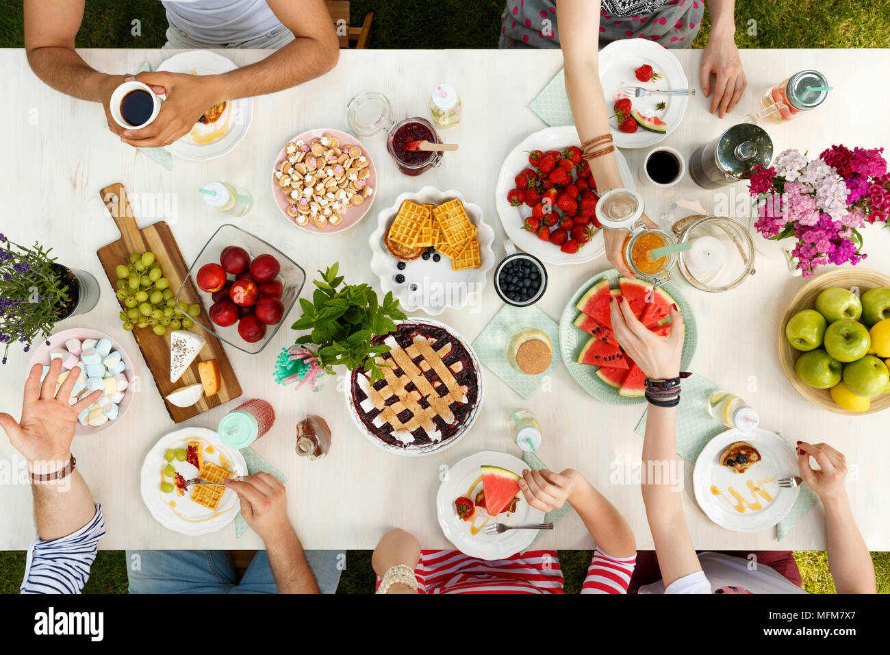 Gli studenti di mangiare un pasto sano all'aperto su un tavolo bianco e avere un buon tempo Foto Stock