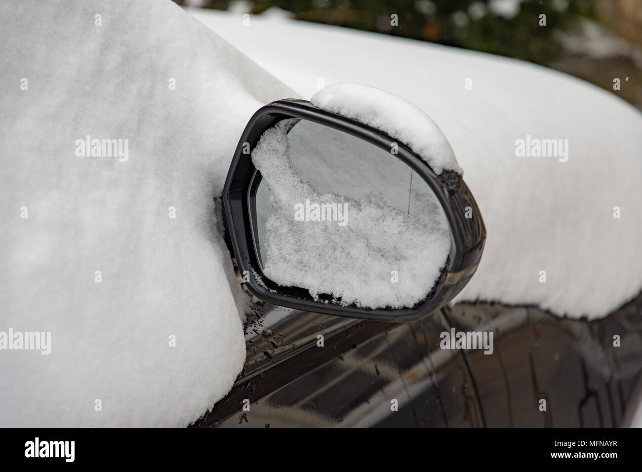 Neve su auto specchio di annunci Foto Stock