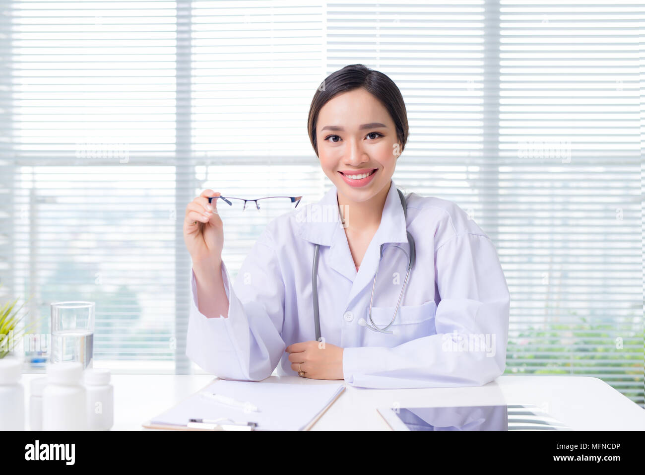 Oculista femmina dando un paio di occhiali Foto Stock