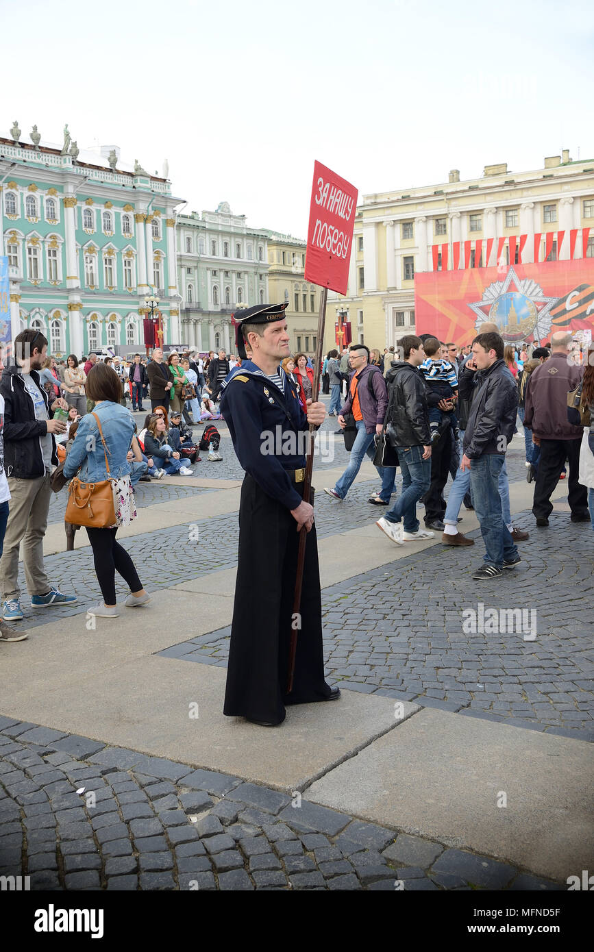 Un marinaio militare nella forma di guerra mondiale II contiene un banner con la scritta "per la nostra vittoria!", la Piazza del Palazzo, la Russia, la Giornata della Vittoria Foto Stock