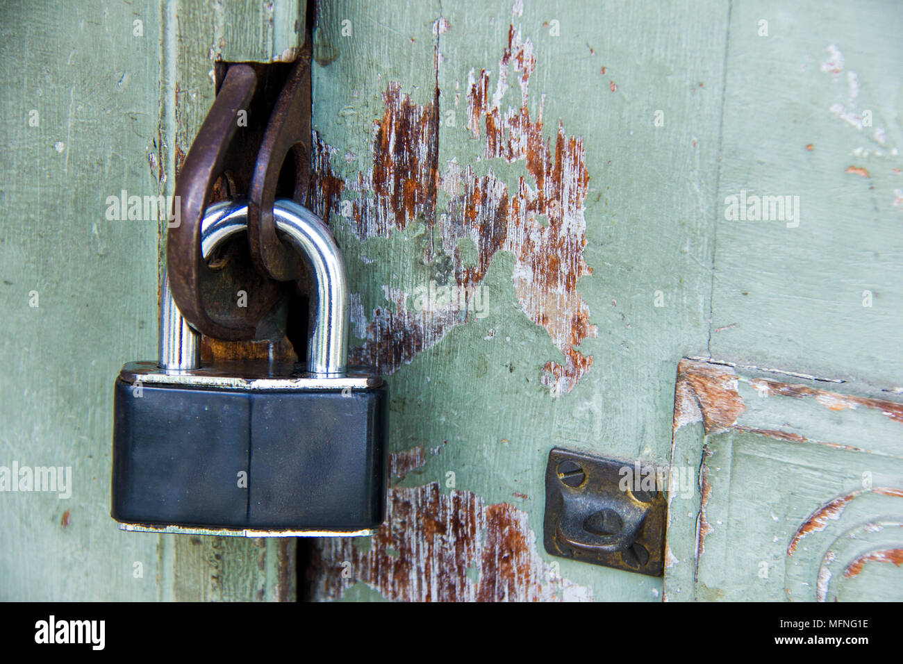Vecchio lucchetto in metallo sulla vecchia dipinta porta in legno Foto Stock