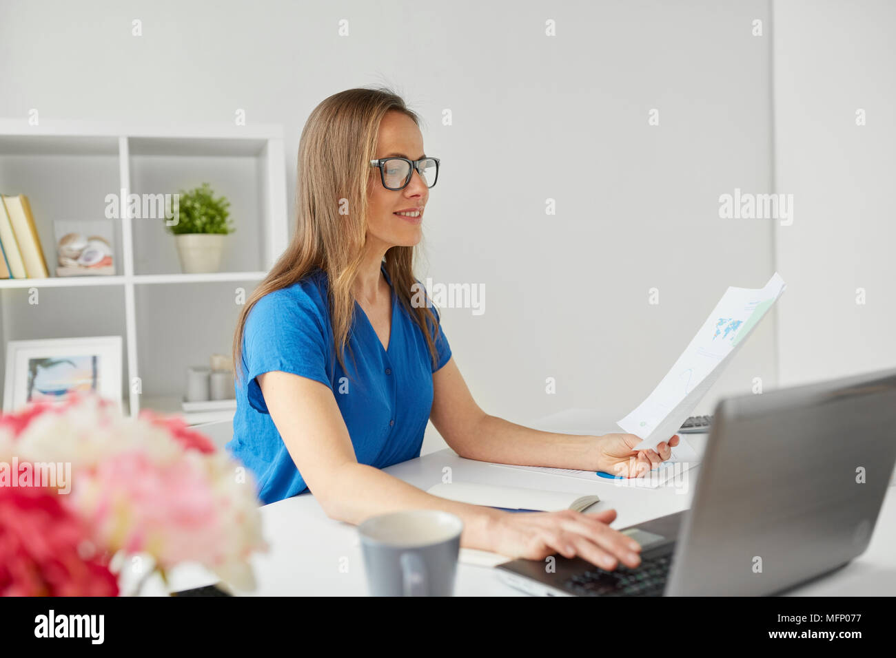 Donna felice con il computer portatile che lavorano a casa o in ufficio Foto Stock