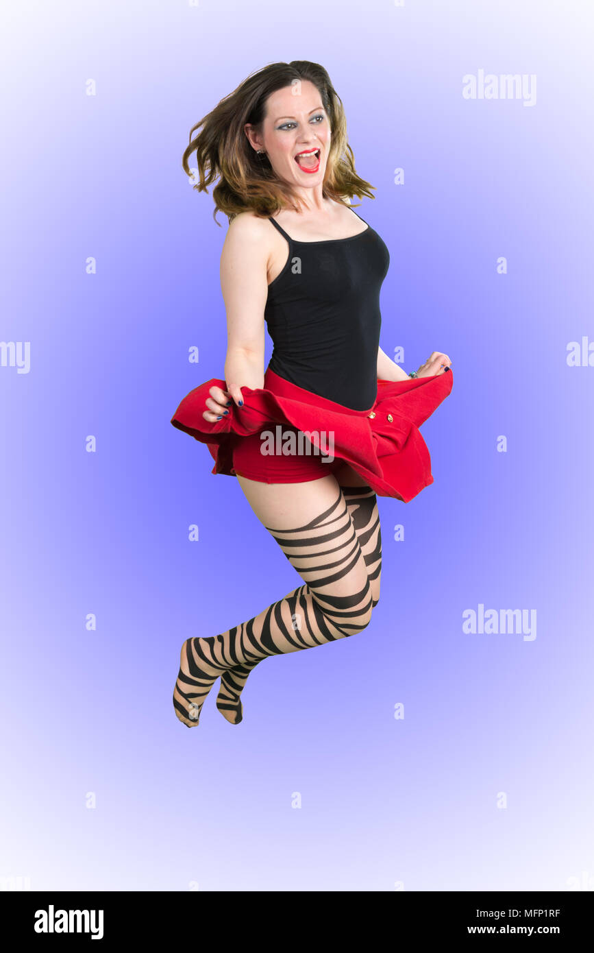 Donna Sexy Jumping. Impostare contro uno sfondo viola Foto Stock
