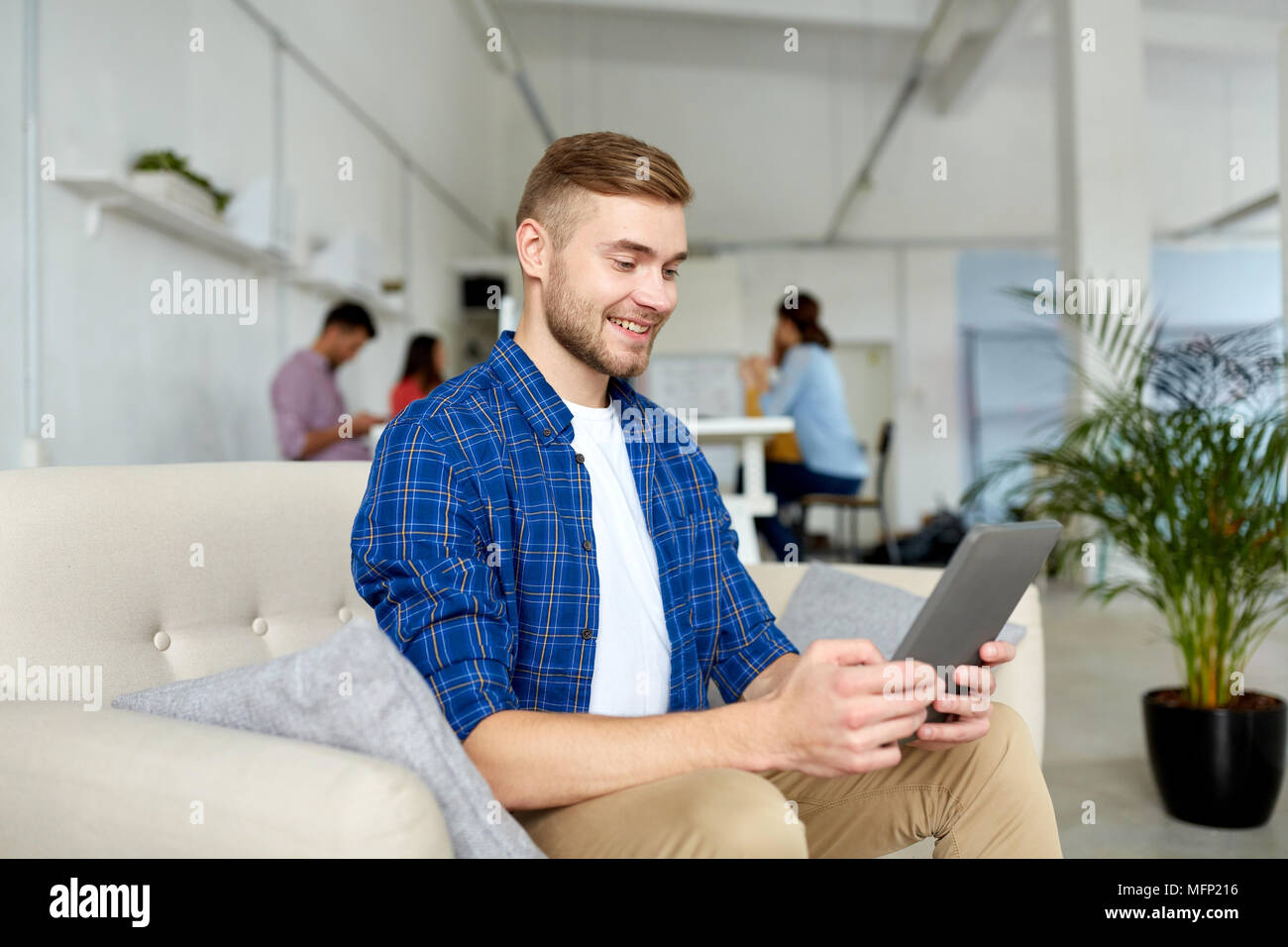 Uomo con tablet pc lavorando in ufficio Foto Stock