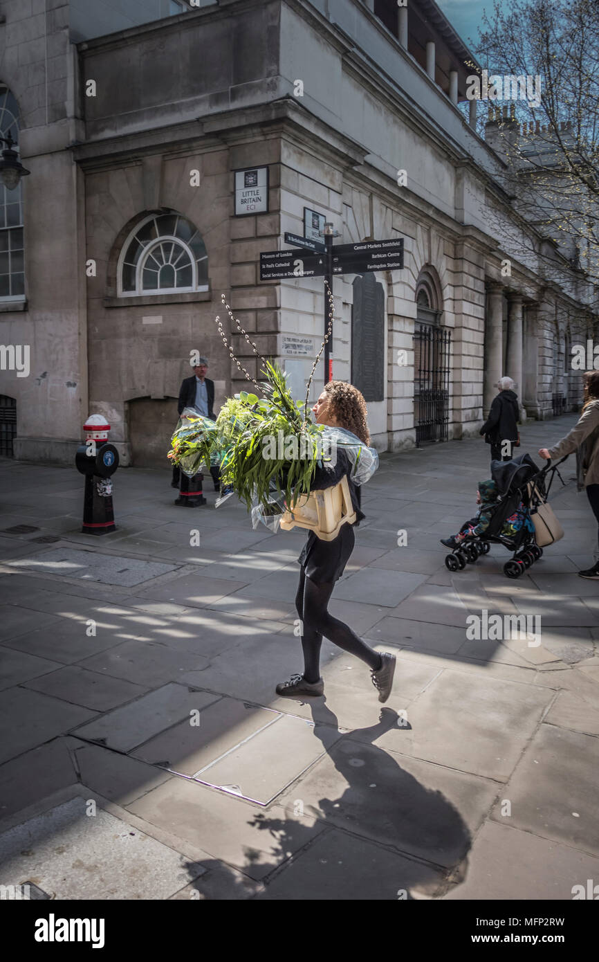 Un fiorista consegna fiori al di fuori di San Bartolomeo del Ospedale (Barts), Smithfield, London EC1, Regno Unito Foto Stock