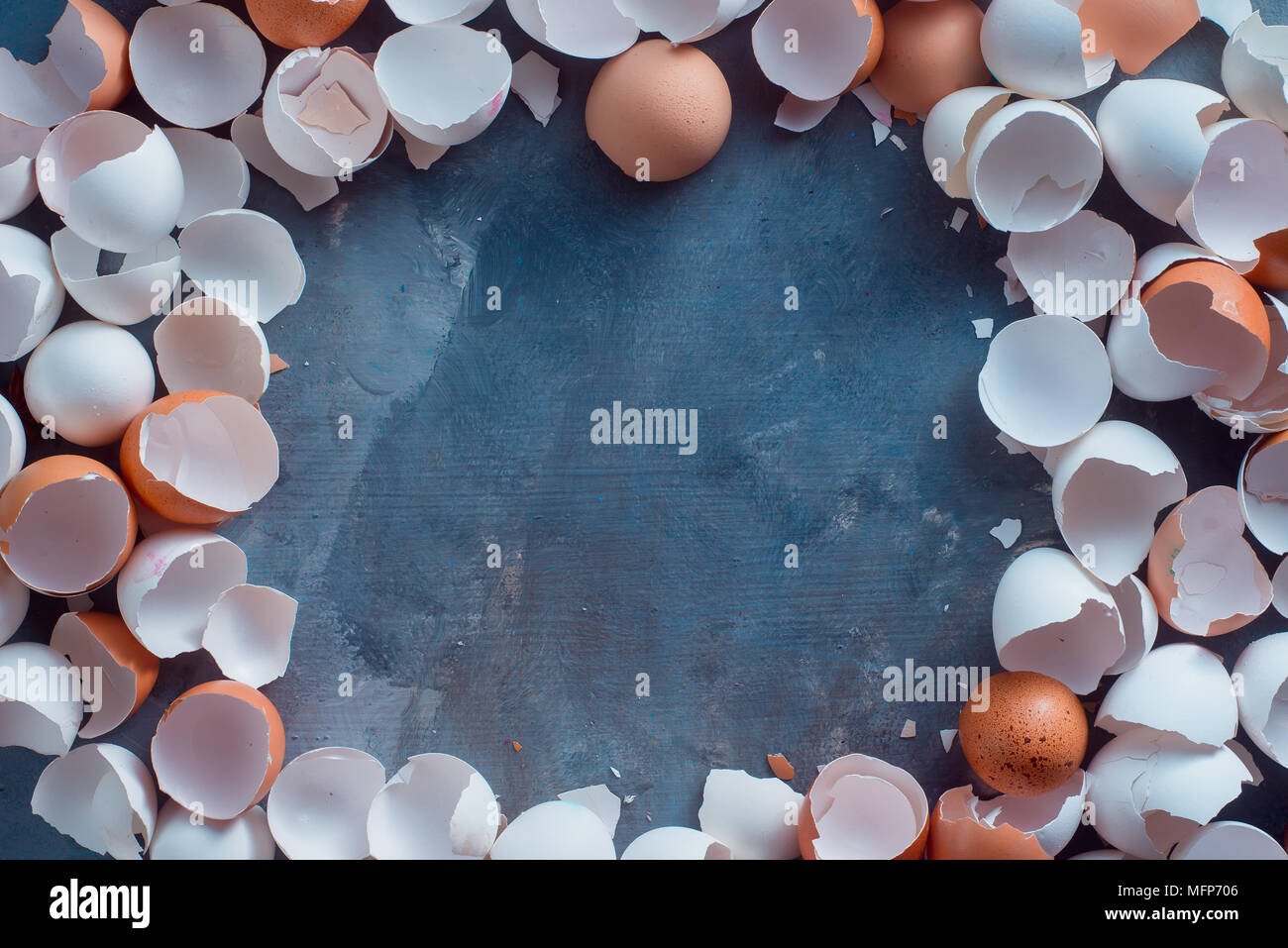 Vuoto, incrinature e rotture di aprire dei gusci di bianco e marrone di uova di gallina pronti per andare in rifiuti organici. Residui di cottura su un concreto sfondo con Foto Stock