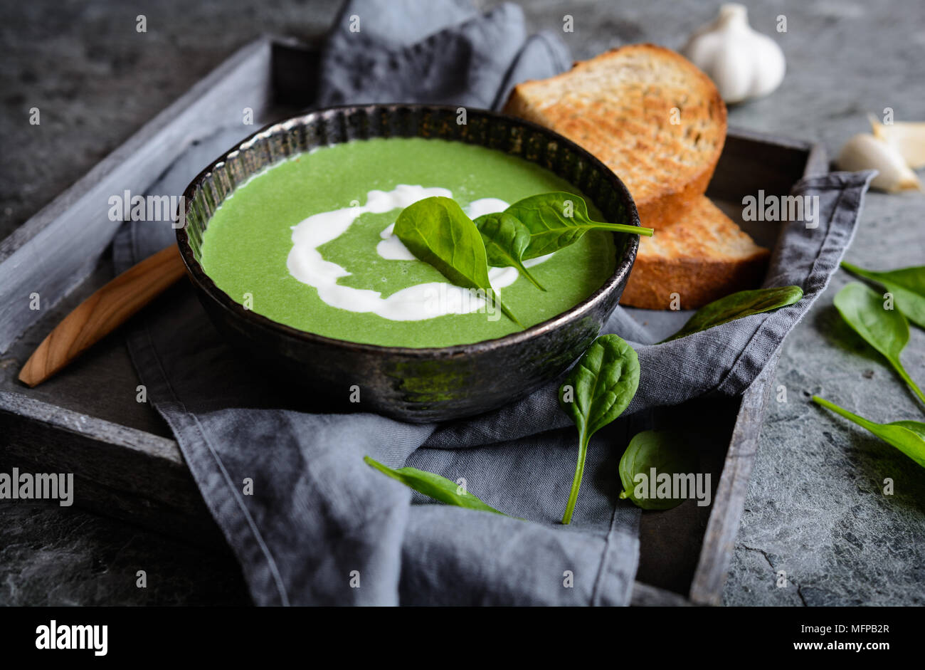 Zuppa di spinaci con aglio e cipolla e panna acida Foto Stock