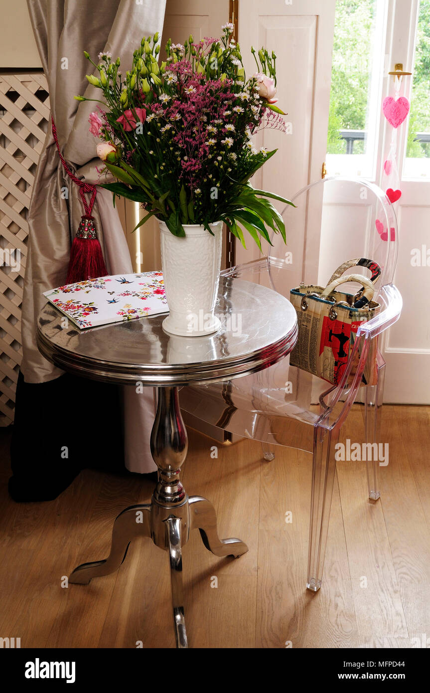 Philippe Starck sedia in argento tabella con la disposizione dei fiori, Varsavia, Polonia Foto Stock