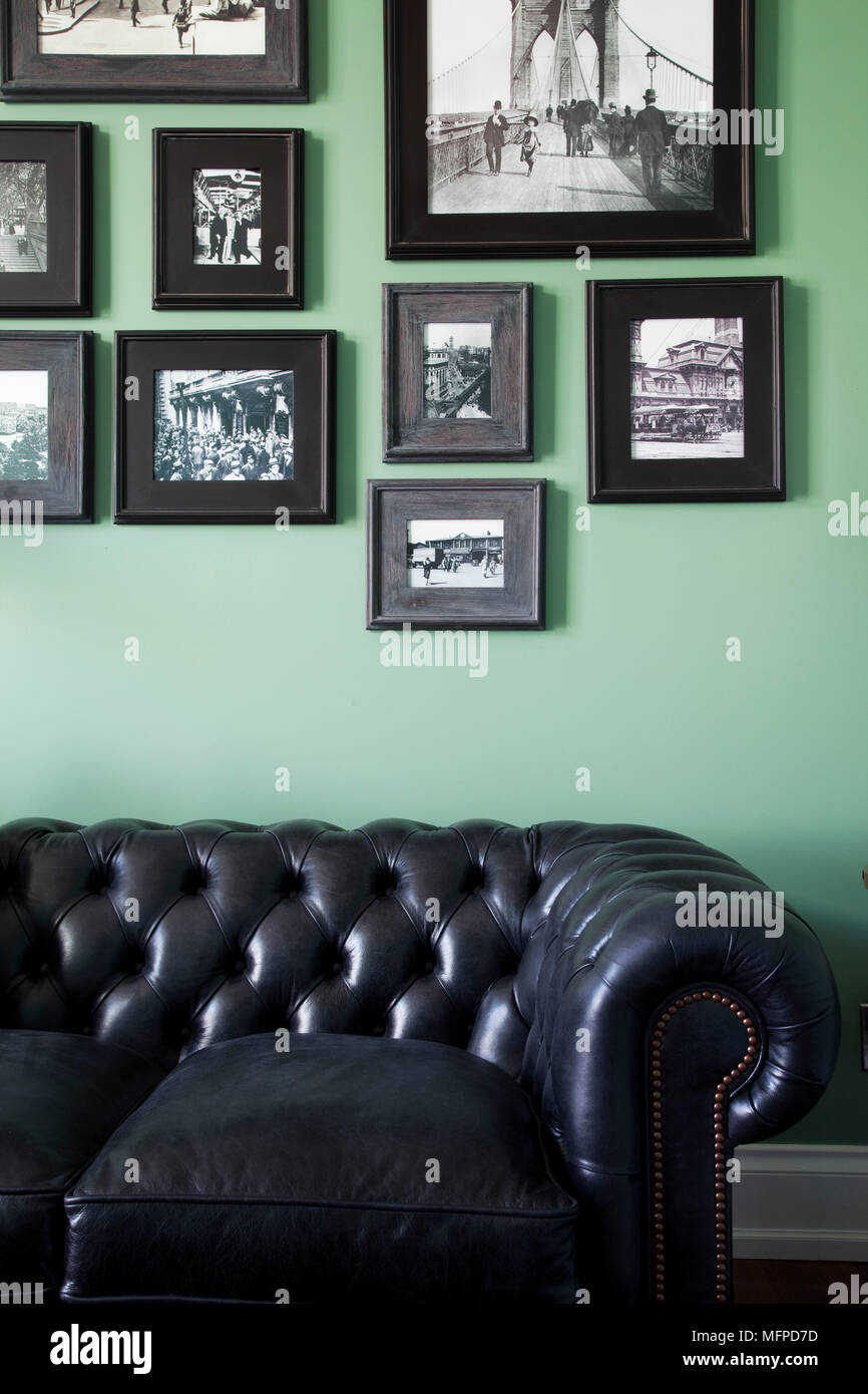 La disposizione delle fotografie al di sopra del cuoio divano Chesterfield in verde studio, New York, Stati Uniti d'America Foto Stock