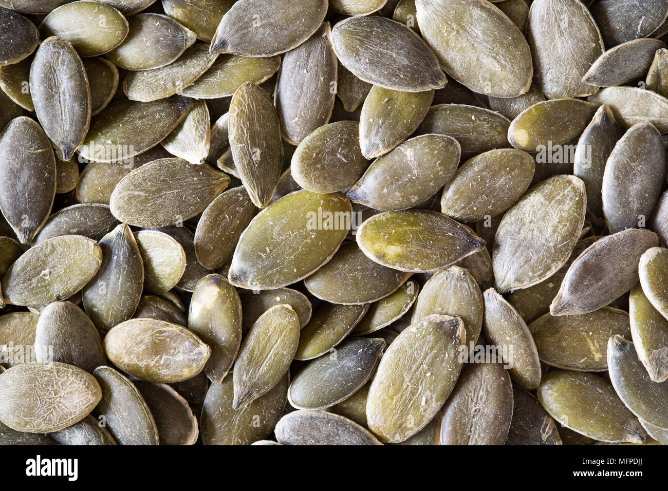 Primo piano di semi di zucca grezzi e organici. Immagine di sfondo del cibo per promuovere i benefici di un'alimentazione sana. Supercibo. Foto Stock