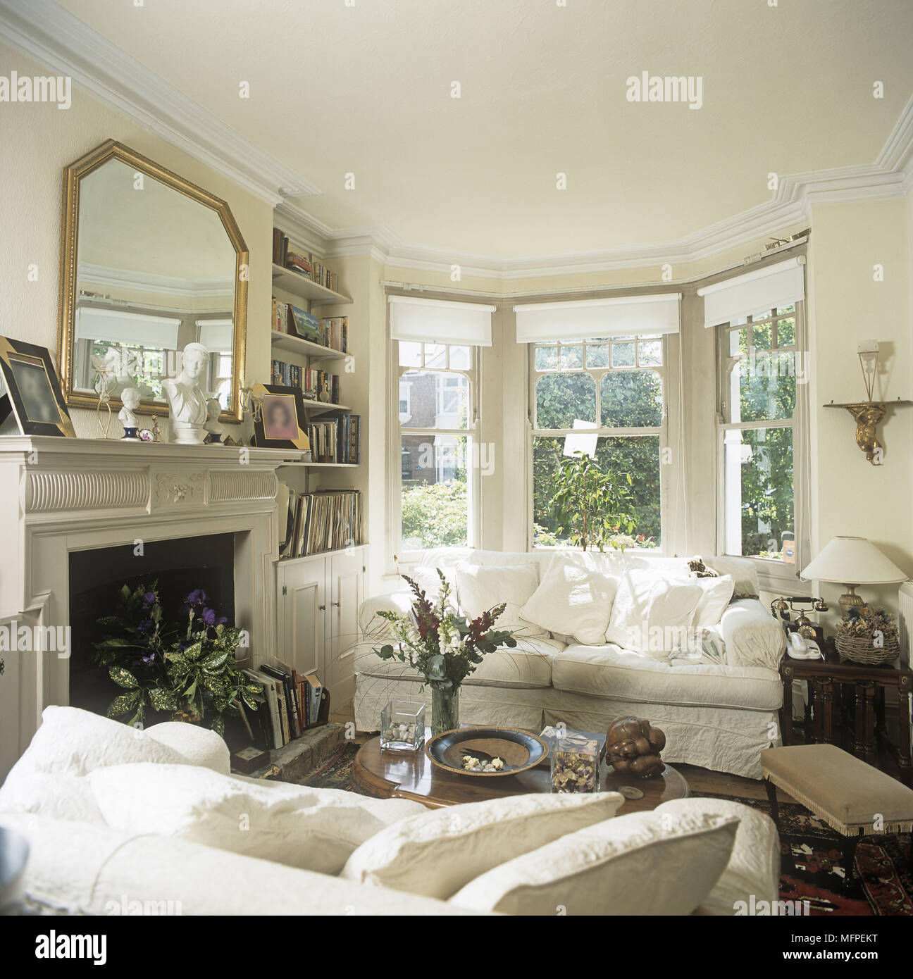 Tradizionale stile edoardiano salotto con divani bianchi camino finestra di baia Foto Stock