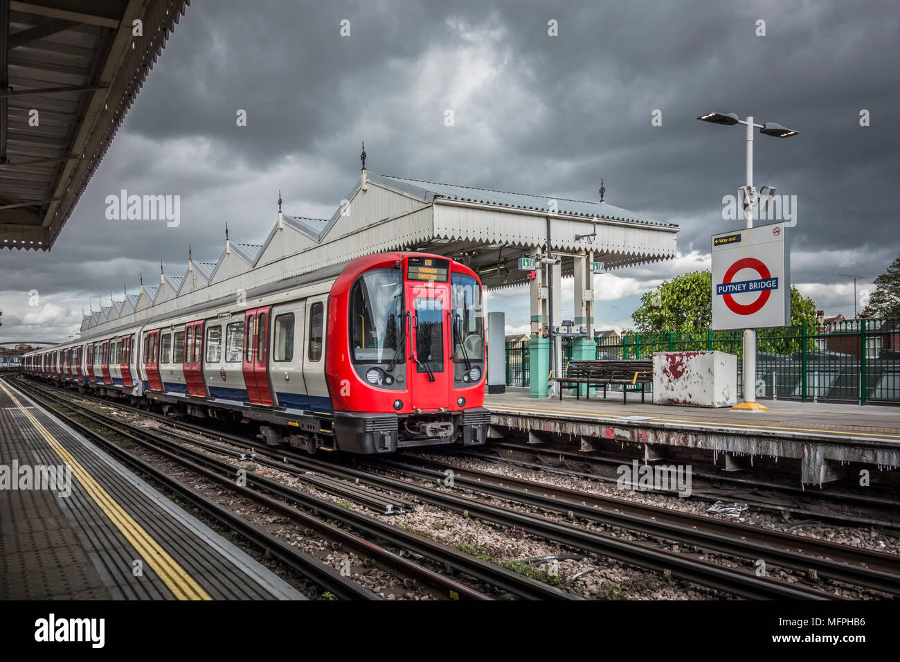 Un treno della District Line che porta alla stazione di Putney Bridge, Londra, Inghilterra, Regno Unito Foto Stock