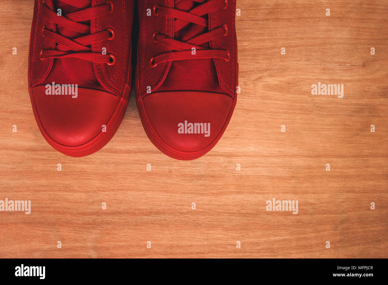 Elegante sneakers rosso su sfondo di legno dal di sopra con lo spazio di copia Foto Stock