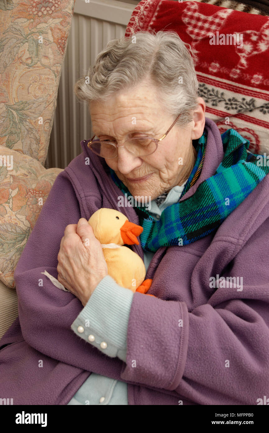 Donna anziana che indossa una giacca di lana e una sciarpa calda in inverno modello di rilascio Foto Stock