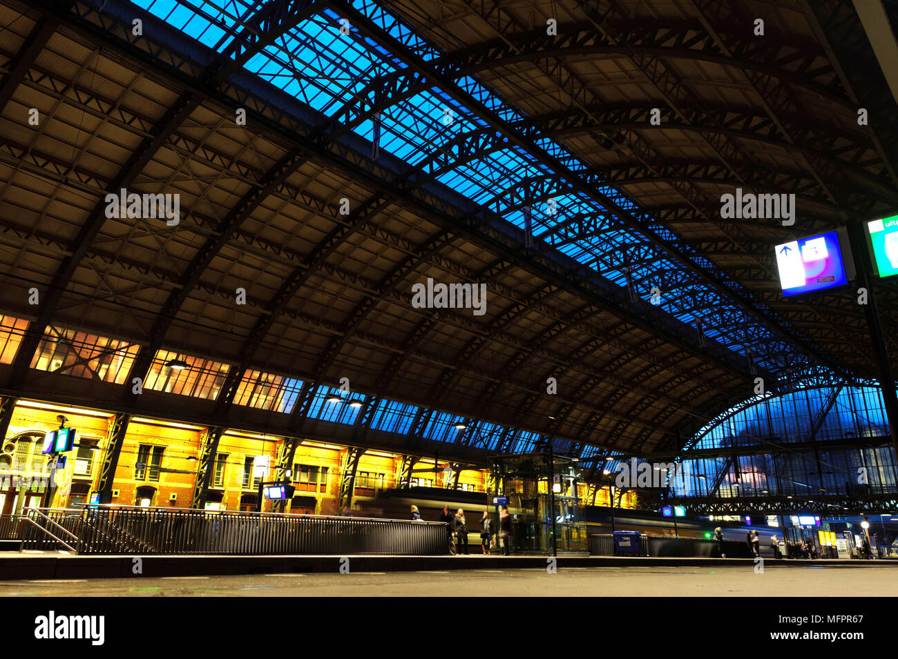 La stazione ferroviaria centrale di Amsterdam di notte. Treno arriva alla stazione. Esposizione lunga notte foto. Foto Stock