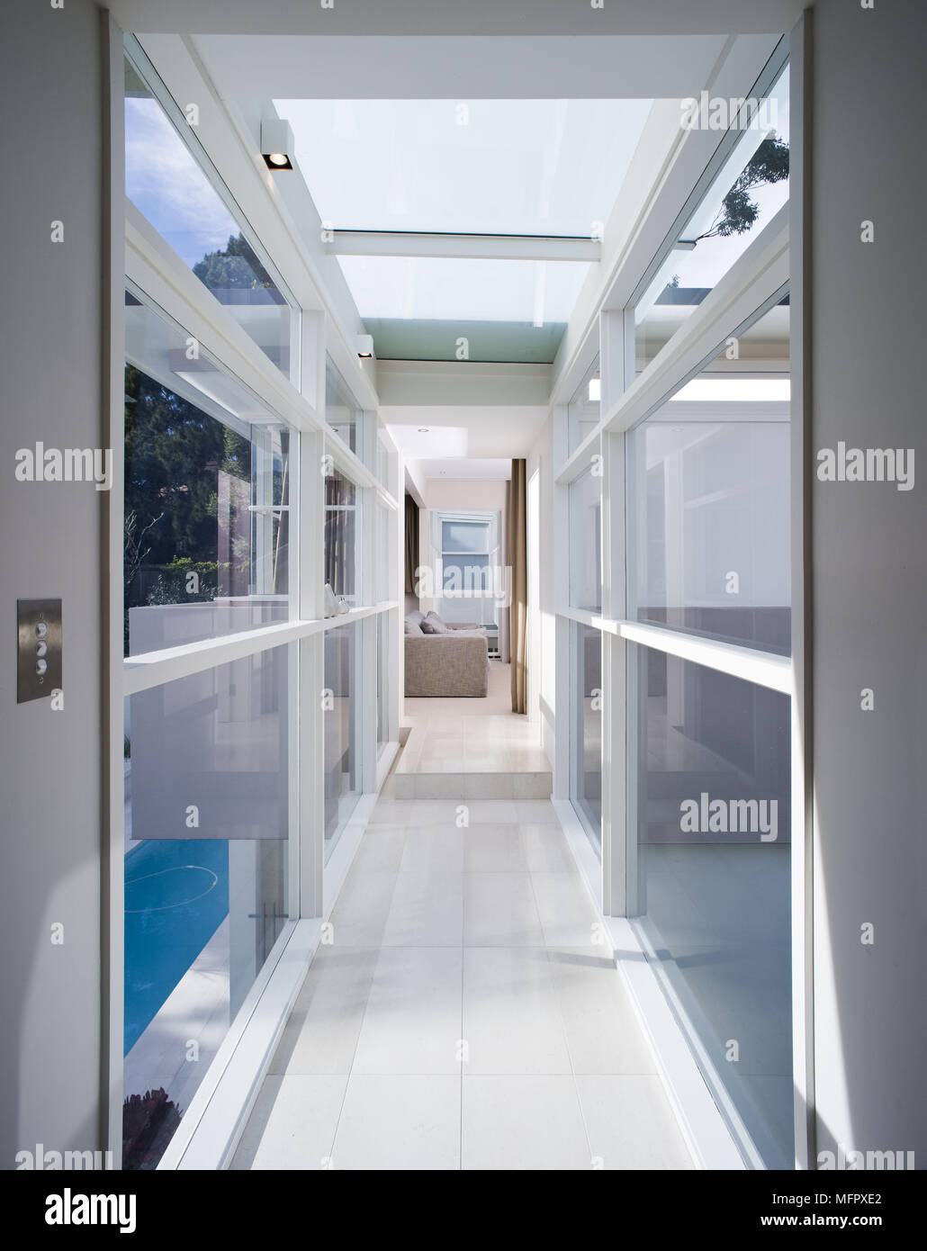 Vista lungo il corridoio di casa moderna con pareti in vetro e tetto Foto Stock