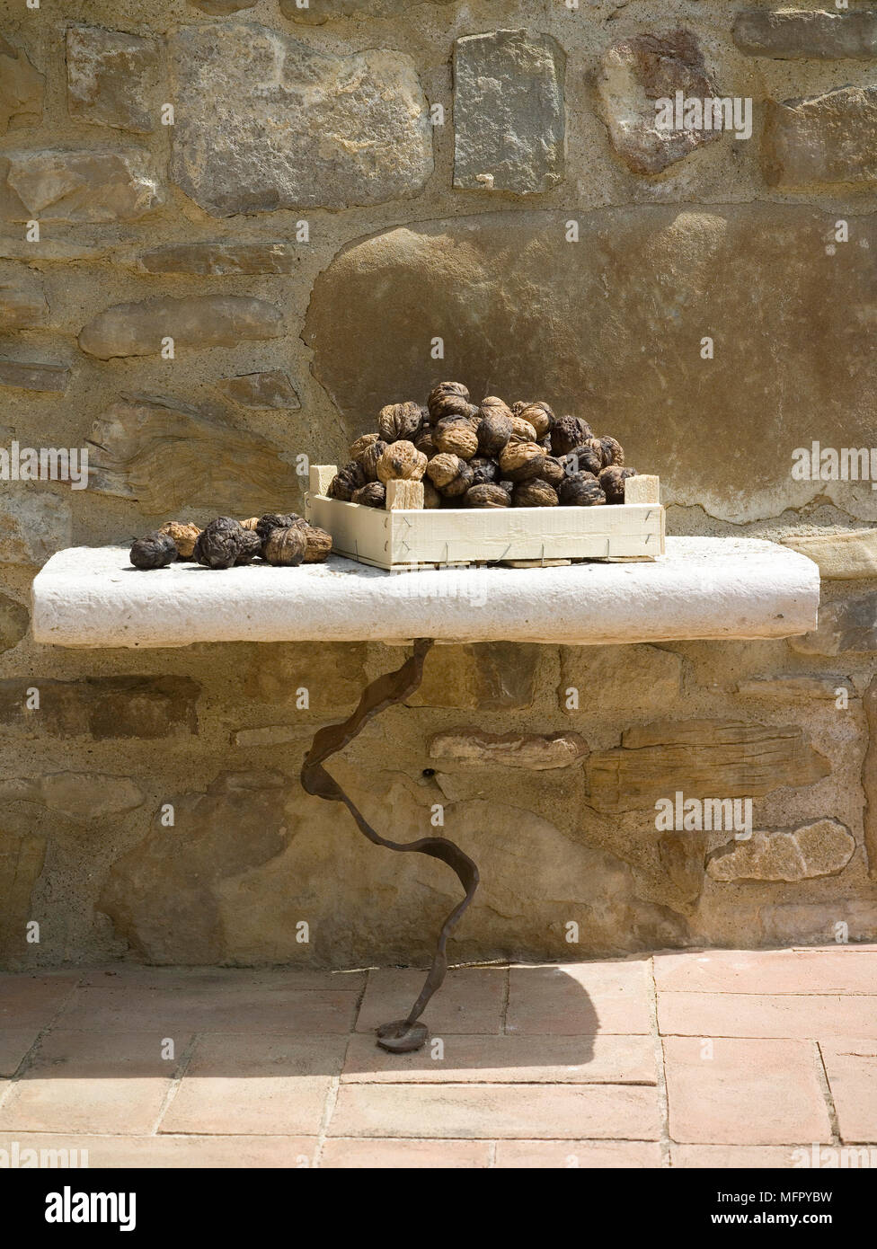 Tartufi sul tavolo di pietra contro la pietra grezza parete Foto Stock