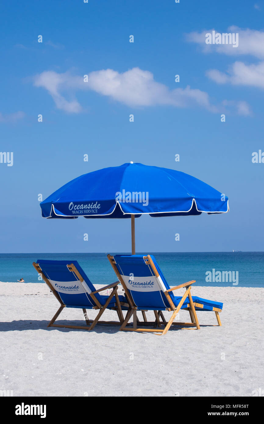 Rilassatevi nel Delray Beach Florida sulla sabbia, sotto un ombrellone con sdraio guardando il mare blu profondo. Foto Stock