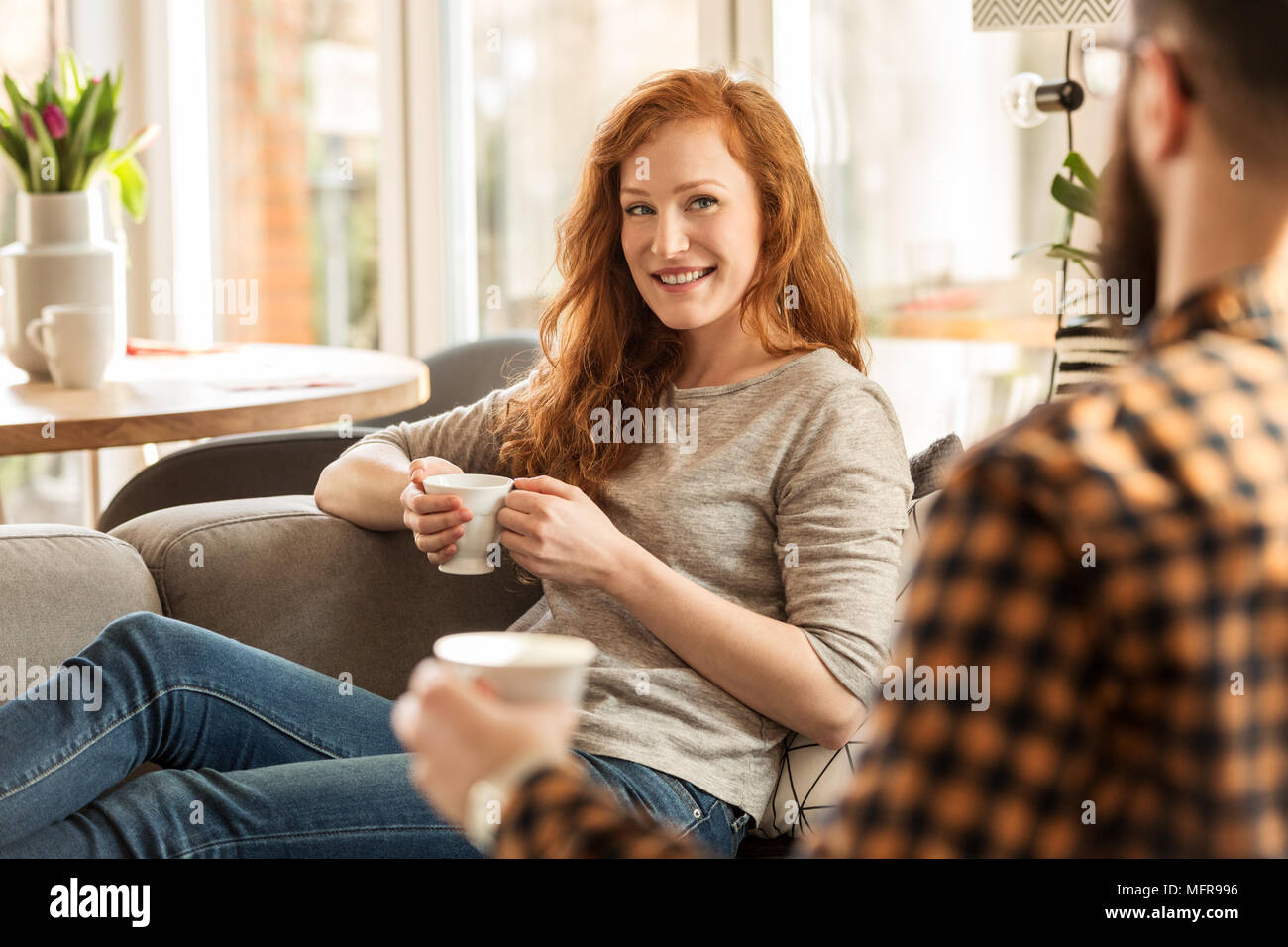 Donna sorridente bere il tè e guardando con amore al suo marito Foto Stock