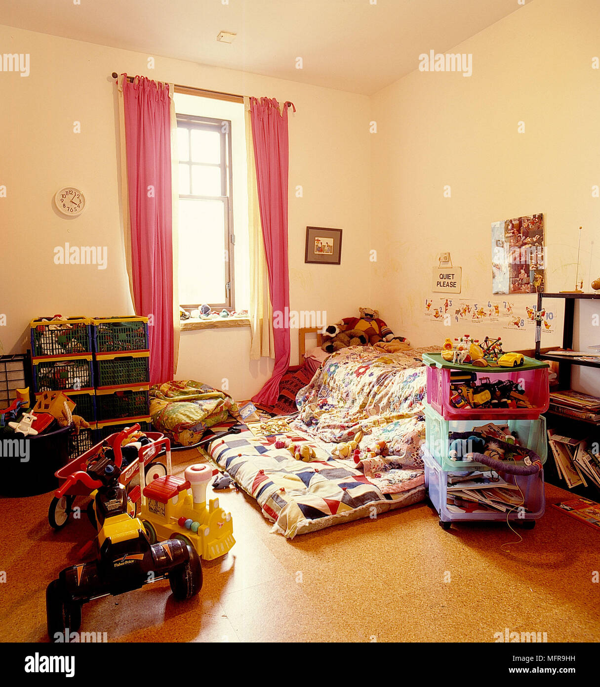 Bambino? Paese camera da letto pareti neutre letto materasso Copertine colorate scatole di impilamento archiviato con giocattoli unità laterale a tre ruote bicyce immagini incorniciate reces Foto Stock