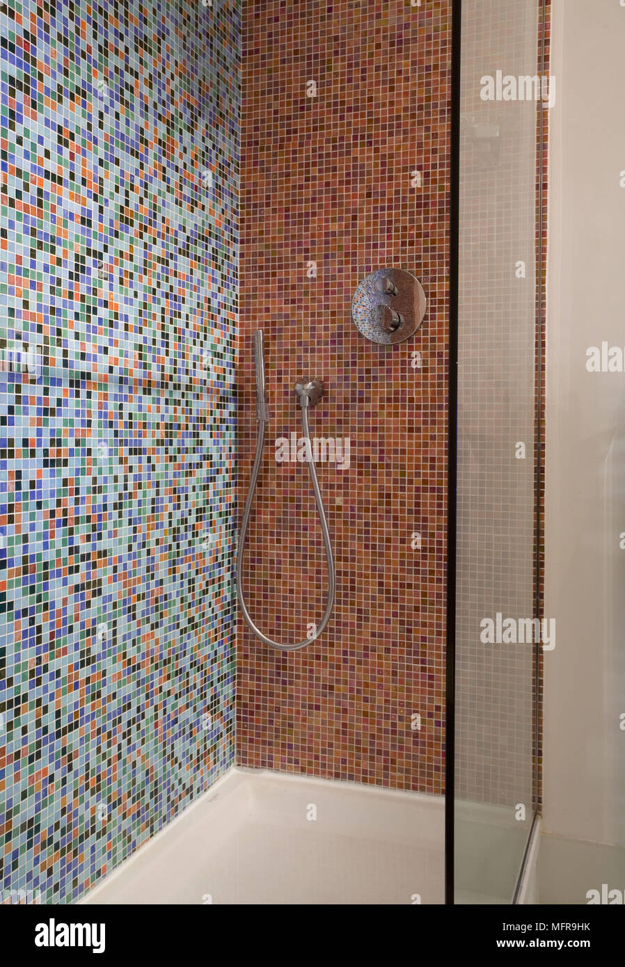 Chrome tocca il montaggio nella cabina doccia con pareti rivestite con mosaici in ceramica Foto Stock