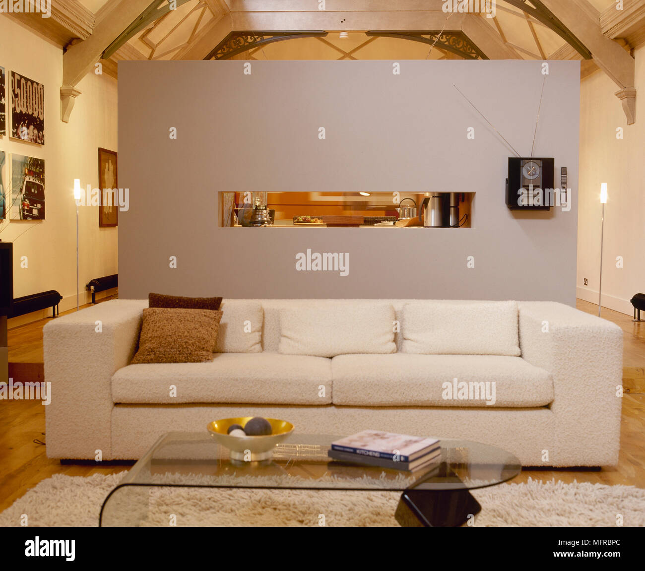 Soggiorno con divano letto, tabella di caffè di vetro, parete divisoria, e  il soffitto a travi Foto stock - Alamy